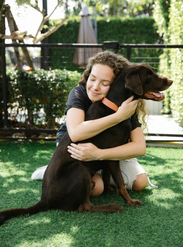 Mulher abraçando seu cachorro
